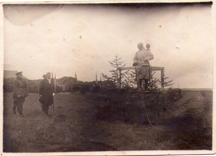Selle foto kohta tegin päringu filmiarhiivi ja vastus oli selline:<br /> Arvan, et tegemist võib olla Poola <br />välisministri Josef Beck'i visiidiga Eestisse. Kui see on nii, siis on foto <br />tehtud 26.juulil 1934.a. Pildil vasakul olev ohvitser on Kaitseväe <br />staabiülem kindral Juhan Tõrvand (uurige, mis kuupäeval saadeti Tõrvand <br />erru), keskel seisev tsivilist võib olla Josef Beck ning kõnepuldis võiks <br />olla EV välisminister Julius Seljamaa. Pilt võib olla tehtud Tallinna <br />ligidal Kaitseväe polügoonil Männikul (tean, et Beck'ile organiseeriti <br />väljasõit kuskile Tallinna ligidale).<br />Tervitades<br />Pearu Tramberg<br />Juhtivkonsultant<br />Eesti Filmiarhiiv
